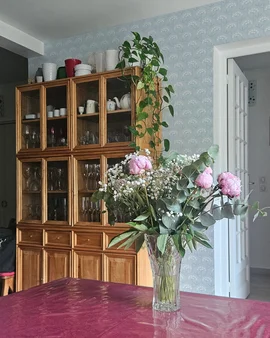 Coastal Living Room with China Cabinet and Delicate Floral Wallpaper